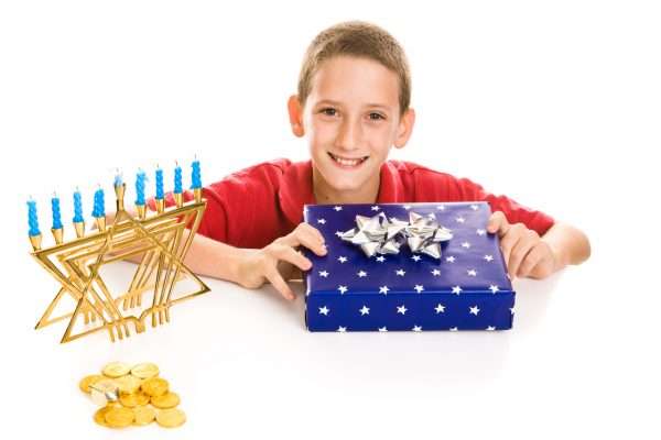 Happy little boy excited about opening his hanukkah gift. Isolated on white.